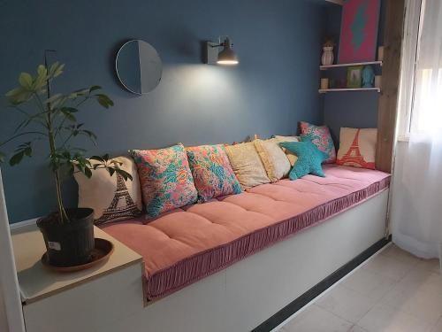 a pink couch with pillows on it in a room at Departamento Central in Arica