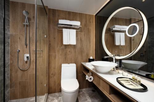 a bathroom with a toilet and a sink and a mirror at Park Hotel Hong Kong in Hong Kong