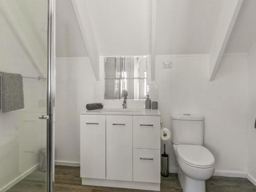 a white bathroom with a toilet and a sink at A la Plage in Cape Woolamai