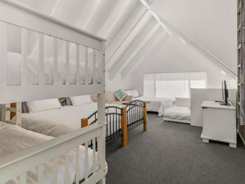 a bedroom with two bunk beds and a tv at A la Plage in Cape Woolamai