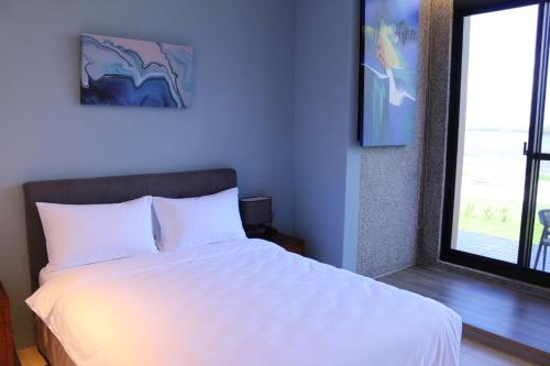 Postel nebo postele na pokoji v ubytování 澎湖拾滬海景會館 Stone Mansion Seaview Hotel