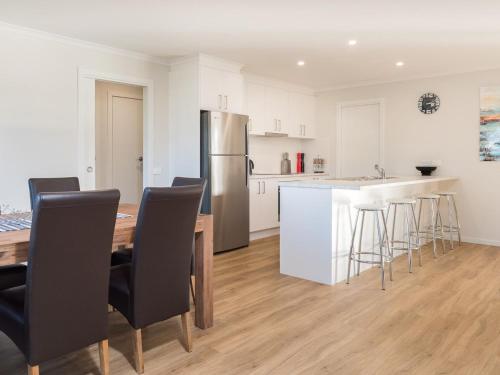 a kitchen with a table and chairs and a refrigerator at A Perfect Ten in Cowes