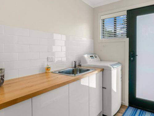 a kitchen with a sink and a washing machine at Waikiki Views in Smiths Beach