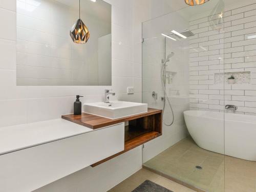 a bathroom with a sink and a bath tub and a sink at Absolutely Beach in Cowes