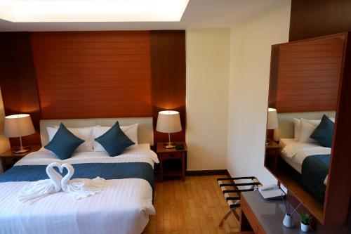 a hotel room with two beds with swans on them at 42Grand Residence in Bangkok