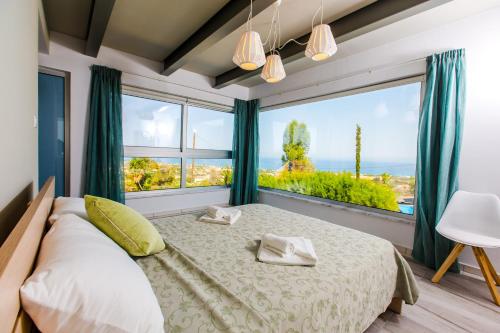 a bedroom with a bed and a large window at Villa Med. Coast Deluxe in Paphos City