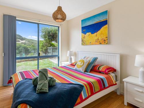 ein Schlafzimmer mit einem Bett und einem großen Fenster in der Unterkunft Adnajur in Surf Beach