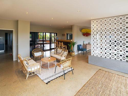 a living room with chairs and a table and a dining room at The Islander in Ventnor