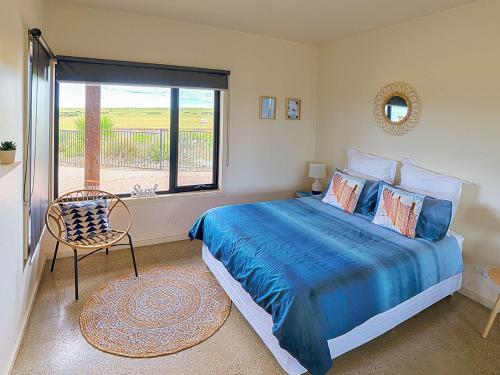 a bedroom with a blue bed and a window at The Islander in Ventnor