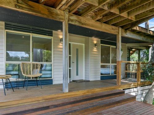 a front porch of a house with a table and chairs at The Deck House in Smiths Beach