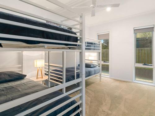 a bedroom with two bunk beds and a window at Swan Bay Views in Surf Beach