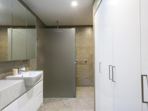 拉伊的住宿－黑麥漂流木公寓，白色的浴室设有水槽和淋浴。