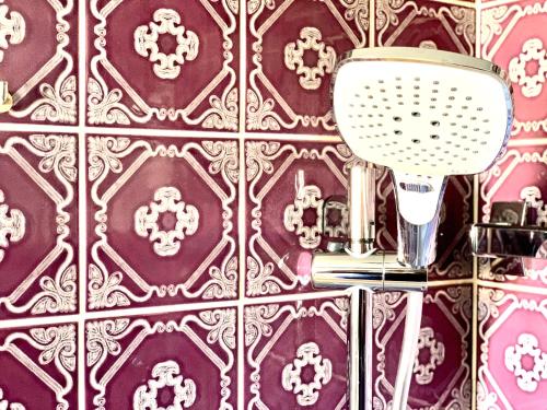 a bathroom with a purple tile wall with a mirror at Elegant City Apartment - by Nahuen Suites in Graz