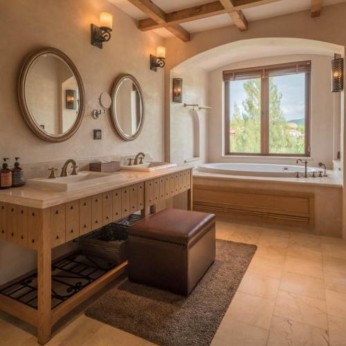 a large bathroom with a tub and a large mirror at Toscana Town Square Suites in Mu Si