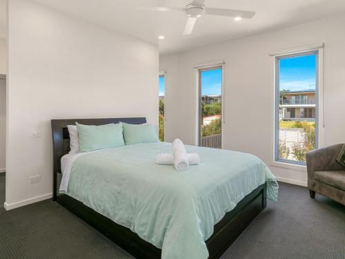 um quarto com uma cama com um urso de peluche em Swan Bay Lookout em Surf Beach