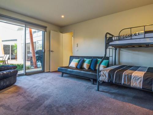 - une chambre avec des lits superposés et un canapé dans l'établissement Beach Retreat on Koala, à Cowes