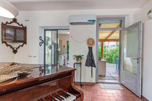 a living room with a piano and a hallway at Casali Marchigiani - Ville vacanza private con piscina in Ostra