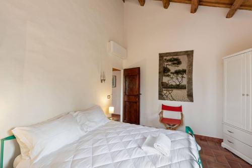 a bedroom with a white bed and a red chair at Casali Marchigiani - Ville vacanza private con piscina in Ostra