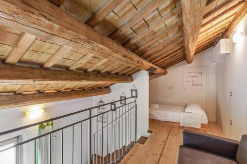 una camera con soffitti in legno e una scala con un letto di Casali Marchigiani - Ville vacanza private con piscina a Ostra