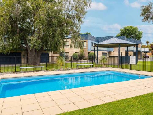 a swimming pool with a gazebo and a building at Sea Breeze - with solar heated pool in the complex in Cowes