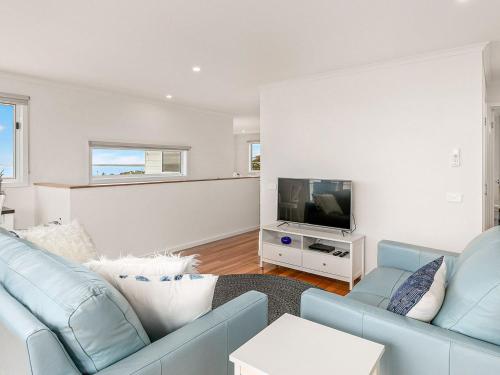 a living room with a blue couch and a tv at San Freemo in San Remo