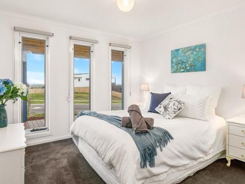 a white bedroom with a bed and windows at San Freemo in San Remo
