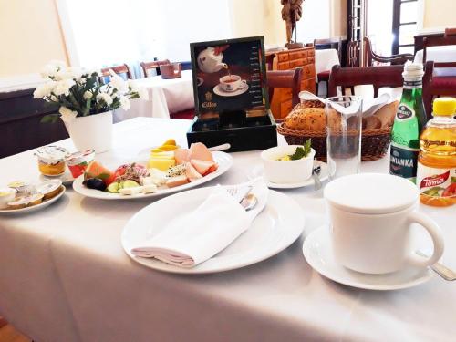 een tafel met borden eten en een kopje koffie bij Hotel Zamek Królewski w Rydzynie in Rydzyna