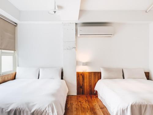two beds in a room with white walls at Star Hostel Taipei Main Station in Taipei