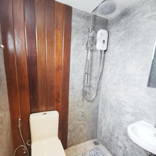 a bathroom with a shower and a toilet and a sink at Stay Here Hostel in Chiang Mai