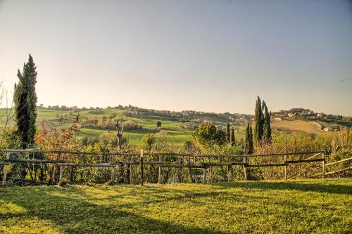 a wooden fence in the middle of a field at Casali Marchigiani - Ville vacanza private con piscina in Ostra