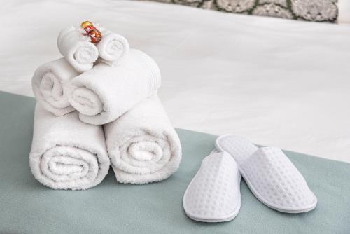 a pile of towels next to a pair of slippers at The Haystack On Homestead in Johannesburg