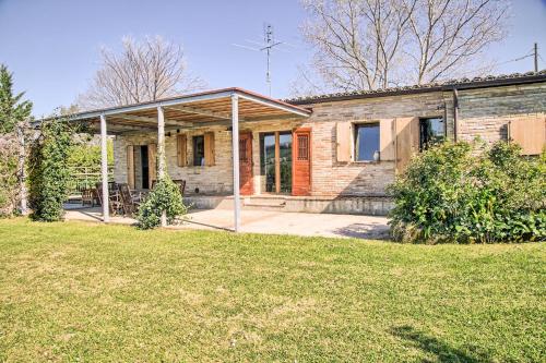 una vieja casa de ladrillo con un patio de hierba en Casali Marchigiani - Ville vacanza private con piscina, en Ostra