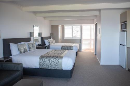 a hotel room with two beds and a couch at Amooran Oceanside Apartments and Motel in Narooma