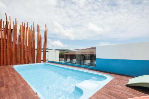 a swimming pool on top of a building at OYO 1074 Fin Hostel in Kata Beach