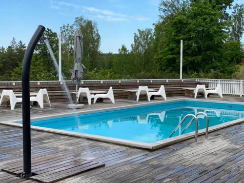 einen Pool auf einer Holzterrasse mit Stühlen und einem Tisch in der Unterkunft First Hotel Bengtsfors in Bengtsfors