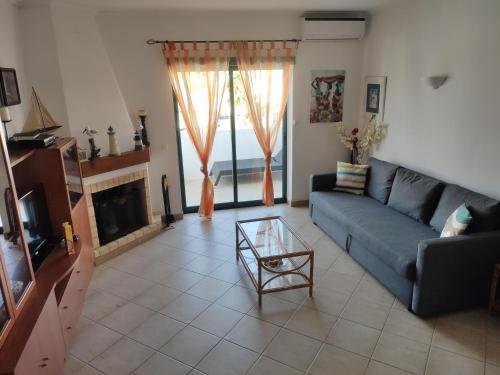 a living room with a blue couch and a fireplace at Erike Guest House in Carvoeiro