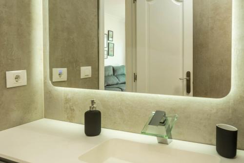 łazienka z umywalką i dużym lustrem w obiekcie Apartamento Happy Dreamer w mieście Puerto Rico de Gran Canaria