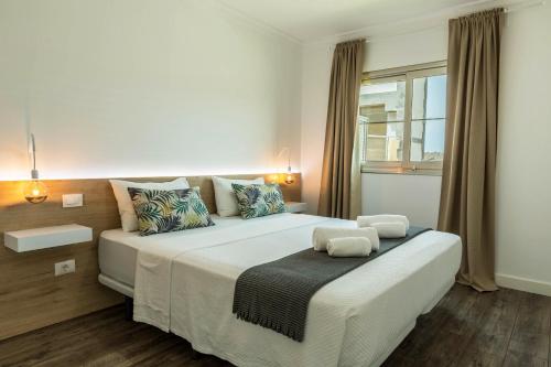uma grande cama branca num quarto com uma janela em Apartamento Happy Dreamer em Puerto Rico de Gran Canaria