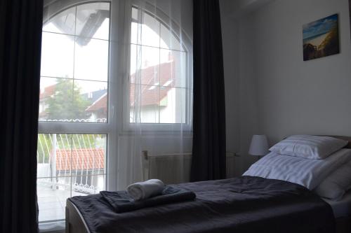 a bedroom with a bed and a large window at Főnix Design Rooms in Debrecen