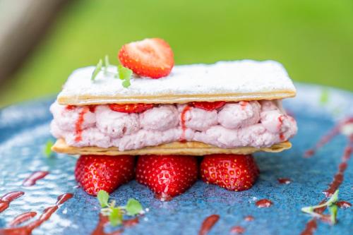 a sandwich with strawberries on a blue plate at Prins Hendrik Texel in Oost