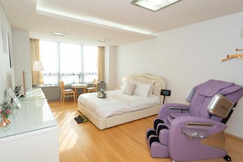 Pokój z łóżkiem, krzesłem i stołem w obiekcie Incheon Airport Capsule Hotel No.1 w mieście Inczon