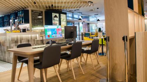 a table with chairs and a computer on top of it at Suites Plaza Hotel & Wellness in Andorra la Vella
