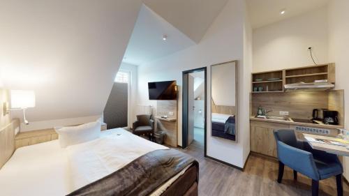 a hotel room with a large bed and a desk at WH Hotels Papenburg Zentrum in Papenburg