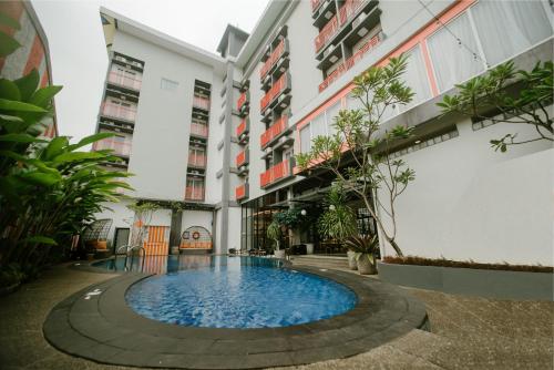 The Bountie Hotel and Convention Centre Sukabumi في سوكابومي: مبنى شقق مع مسبح صغير في الفناء