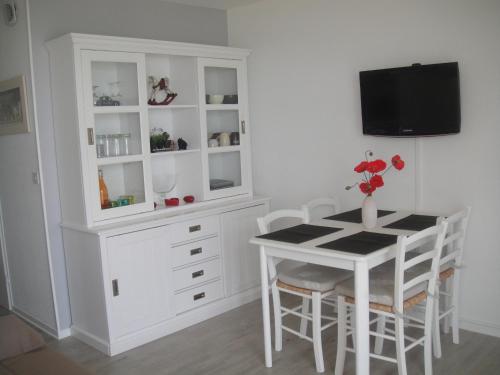 une salle à manger avec un hutte blanche, une table et des chaises dans l'établissement appartement vue mer, à Quiberon