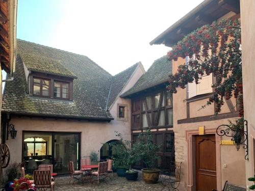 uma casa antiga com um pátio em frente em LA TOUR des fées-spa em Mittelbergheim