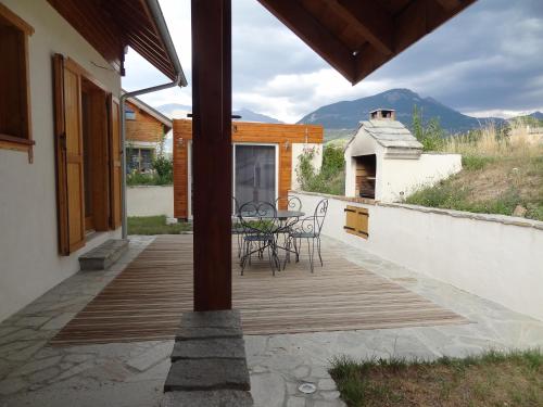 a deck with chairs and a table on a house at Gite de Champ Chaulier in Crots