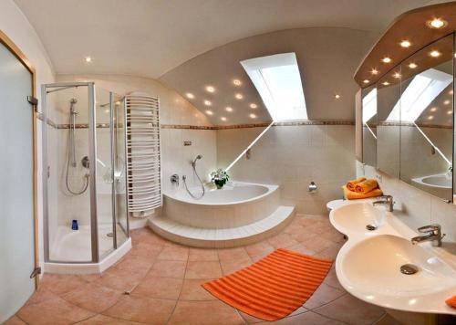 een badkamer met een bad, een douche en een wastafel bij Ferienwohnung Bellissima in Ering