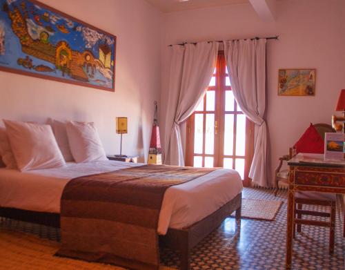 a bedroom with a large bed and a window at Dar Essaada in Essaouira