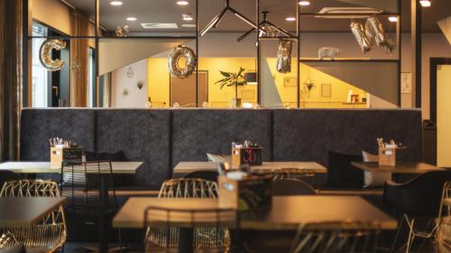 a restaurant with tables and chairs in a room at Holiday Inn - the niu, Coin Frankfurt Ostend by IHG in Frankfurt/Main